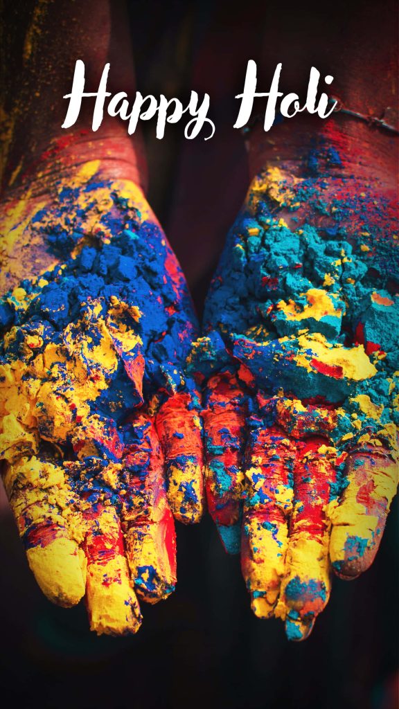 Vibrant Happy Holi wallpaper with cupped hands covered in blue and yellow gulal powder