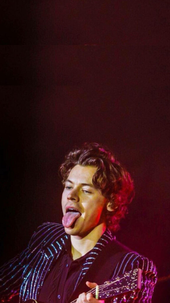 Vibrant Harry Styles Wallpaper: Playful Stage Charisma & Striped Outfit