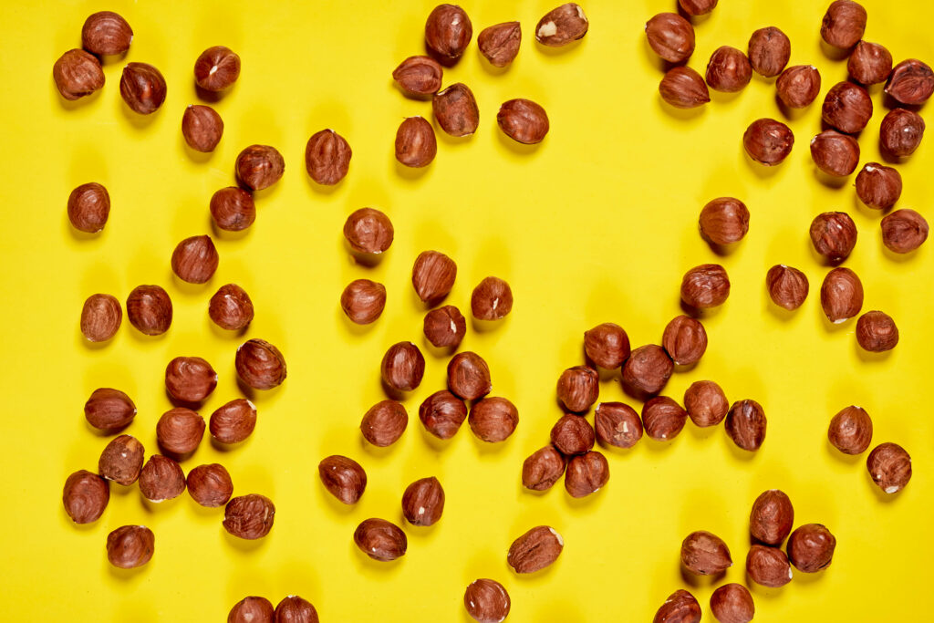 Vibrant Hazelnuts on Yellow: Delicious Wallpaper Background