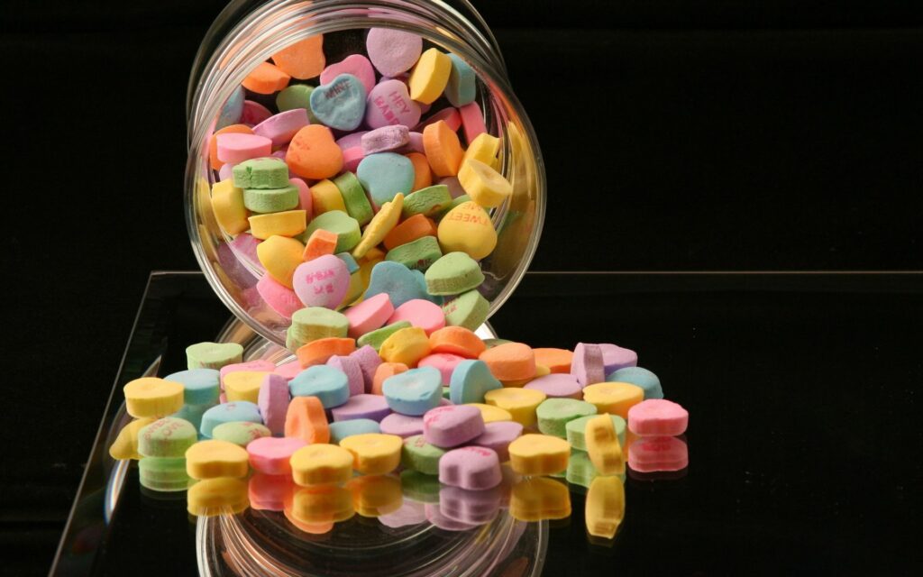 Colorful Heart-Shaped Candies on Reflective Table - Cheerful Wallpaper