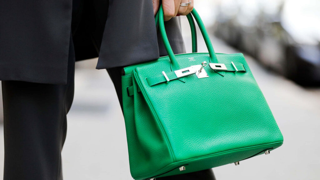 Vibrant Hermes Green Birkin handbag luxury accessory against chic monochrome outfit wallpaper background