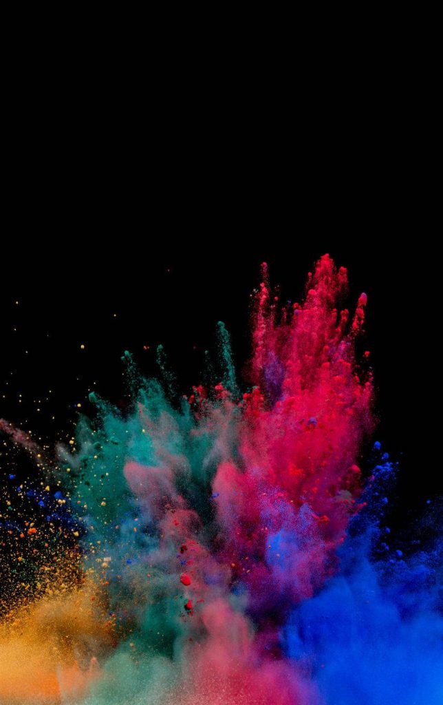 Vibrant Holi powder explosion in red blue pink teal on black background festive wallpaper