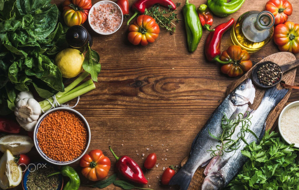 Vibrant Kitchen Setup with Fresh Ingredients for a Homemade Dinner Wallpaper