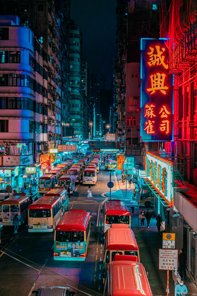 Neon-lit Hong Kong Streets: Bustling Nightscape with Iconic Red Buses Wallpaper