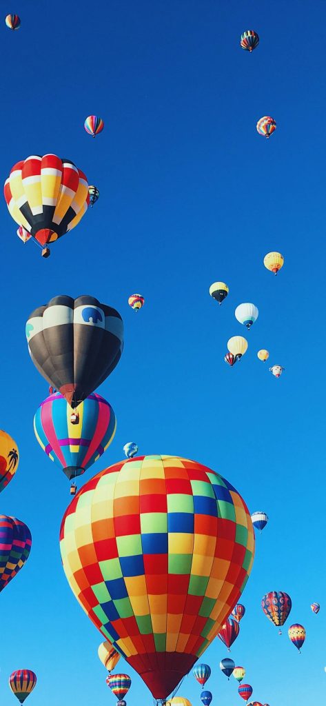 Vibrant multicolored hot air balloons soaring in a clear blue sky high definition wallpaper background
