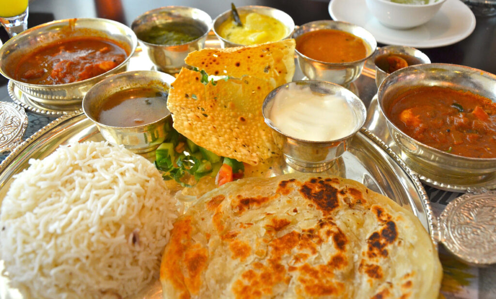Vibrant Indian Food Platter: Rice, Paratha & Curries Wallpaper
