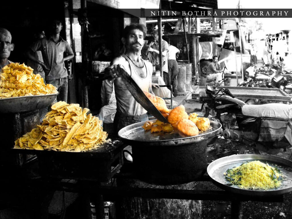 Vibrant Indian Street Food: Grayscale Photo with Colorful Crispy Snacks Wallpaper