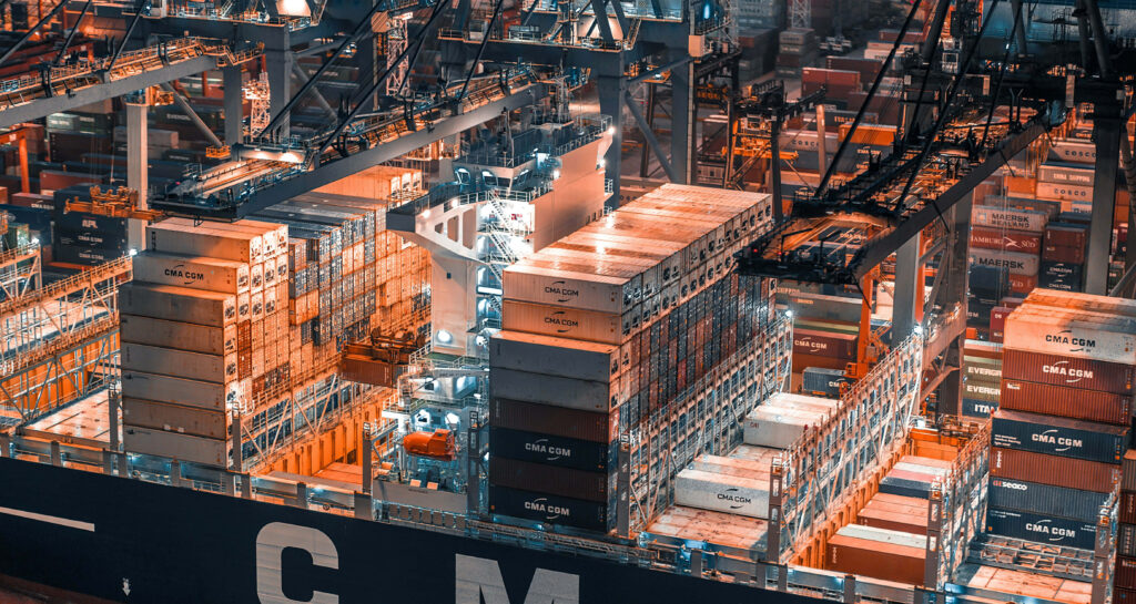 Industrial factory with colorful shipping containers and cranes in a busy shipping yard wallpaper