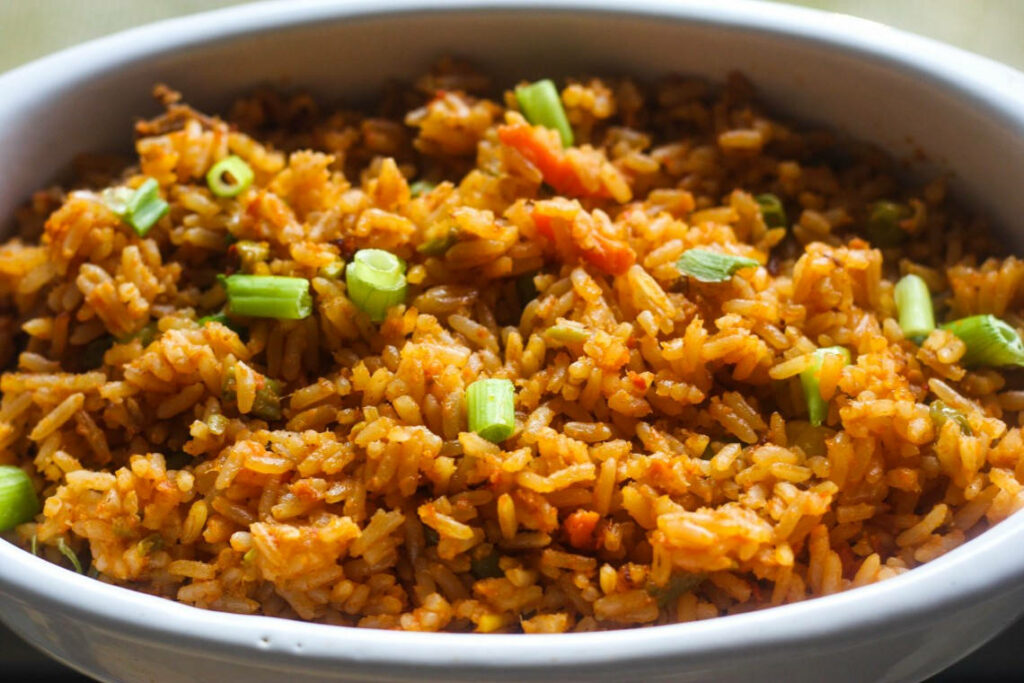 Vibrant Jollof Rice Wallpaper: Savory Dish with Fresh Green Onions