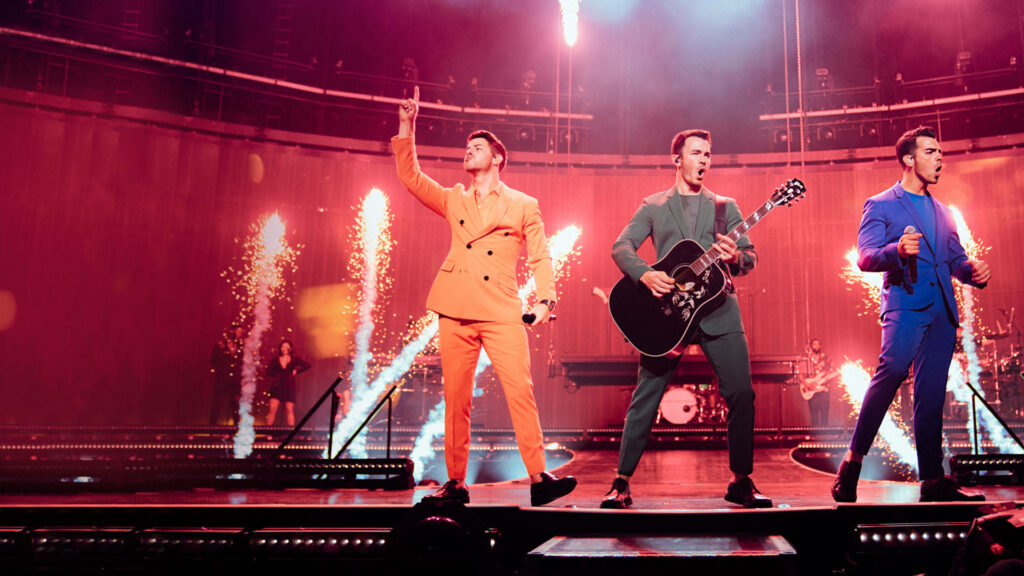 Dynamic Jonas Brothers Concert Wallpaper with Fiery Pyrotechnics