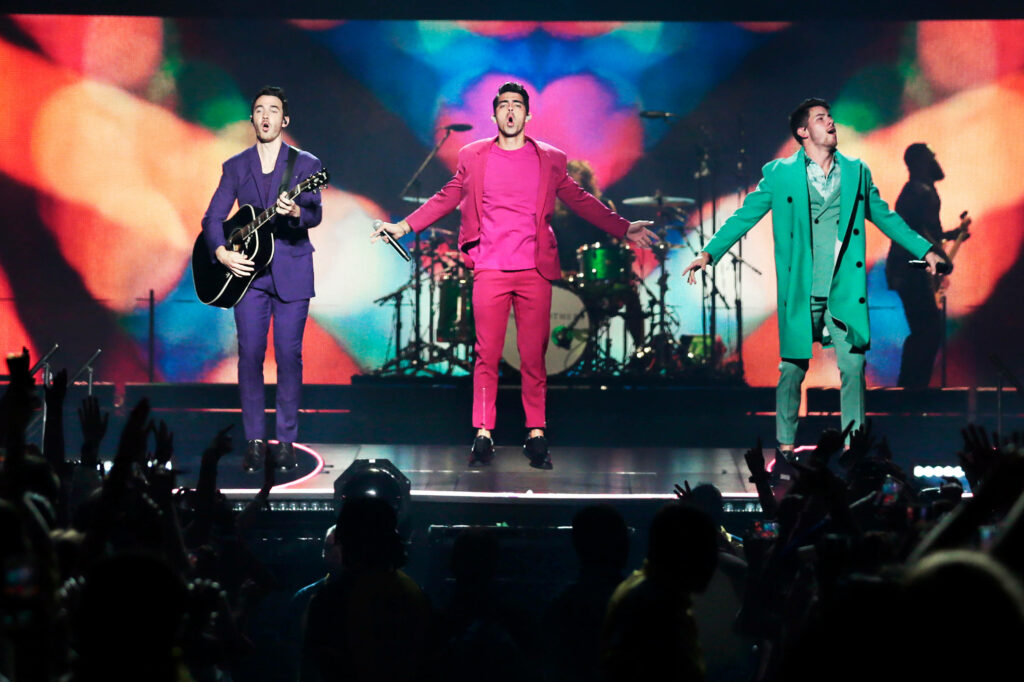 Vibrant Jonas Brothers Wallpaper: Colorful Stage Performance & Audience