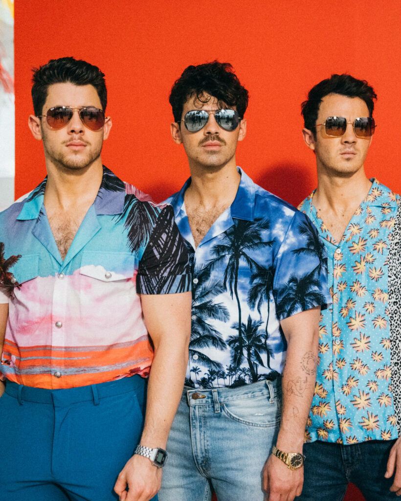 Colorful Jonas Brothers Wallpaper: Tropical Vibe on Bold Red Background