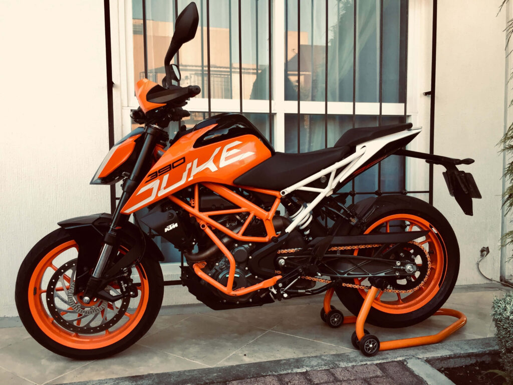 Vibrant Orange KTM Duke 390 Wallpaper Against Modern Backdrop