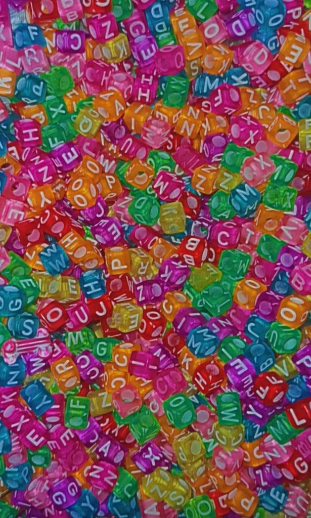 Colorful Kidcore wallpaper with translucent neon alphabet beads in pink green orange blue