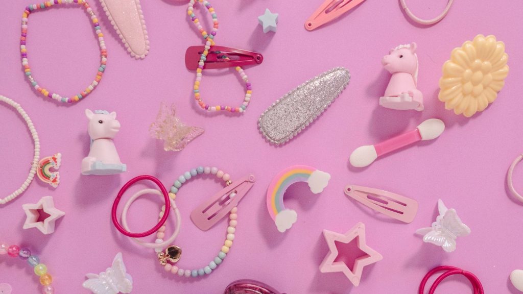 Vibrant Kidcore desktop wallpaper with colorful hair clips bracelets unicorns on pink background