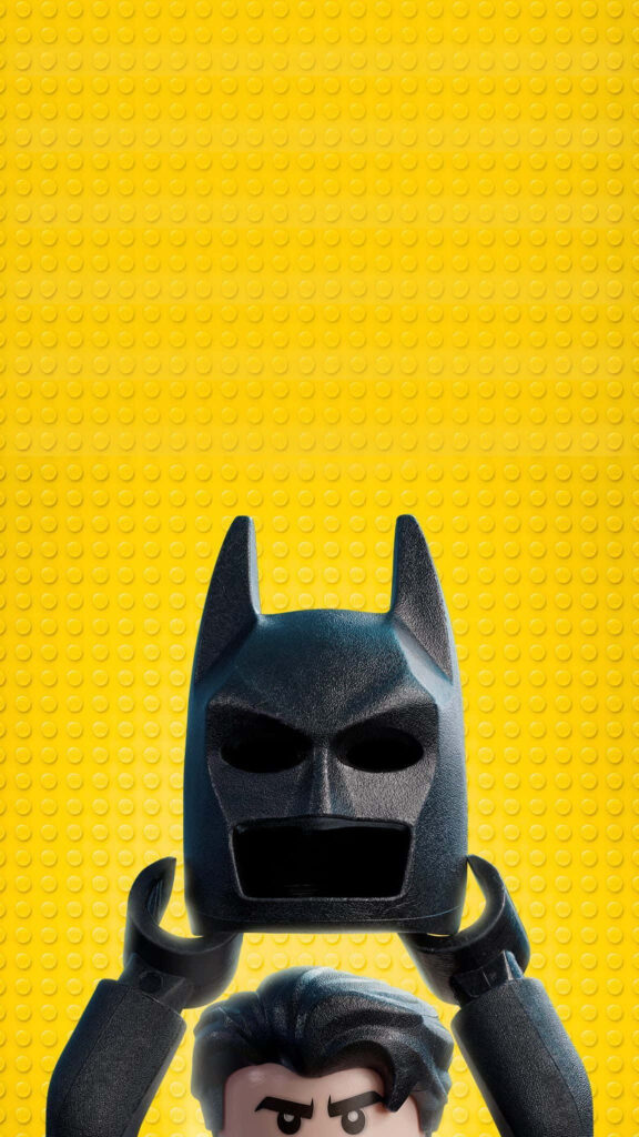 LEGO Batman Android wallpaper with figure holding black mask bright yellow LEGO brick background
