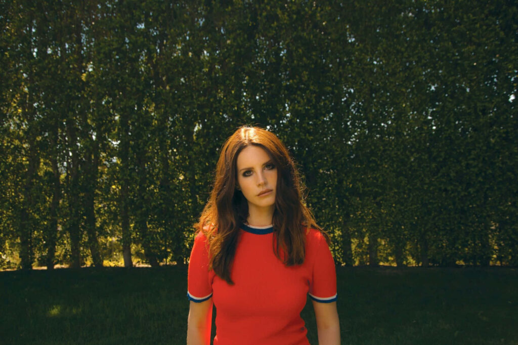 Vibrant Lana Del Rey Wallpaper: Striking Outdoors in Red Shirt