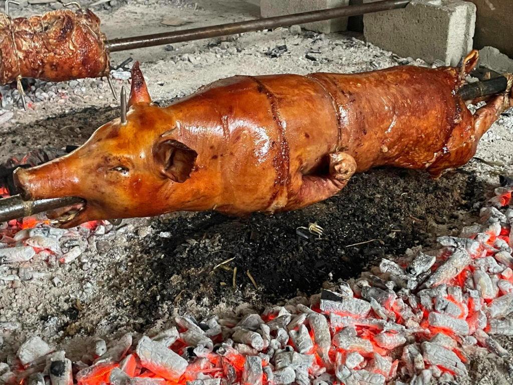 “Roasting Lechon Wallpaper: Crispy Golden Skin Over Open Fire”