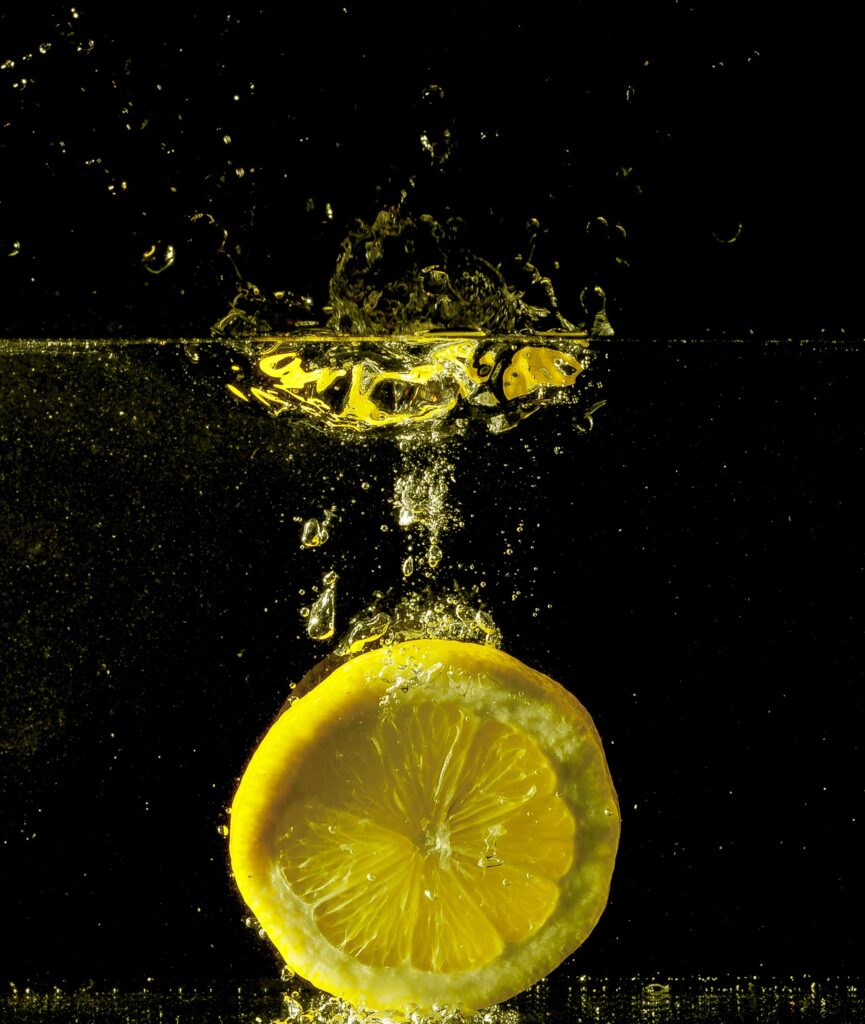 Vibrant Lemon Splash Wallpaper: Dynamic Water Ripples on Dark Canvas