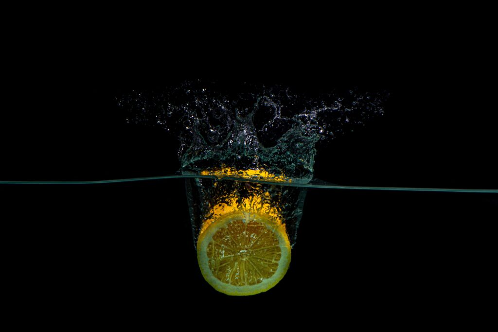 Lemon Slice Splash Wallpaper: Vibrant Black Background Design