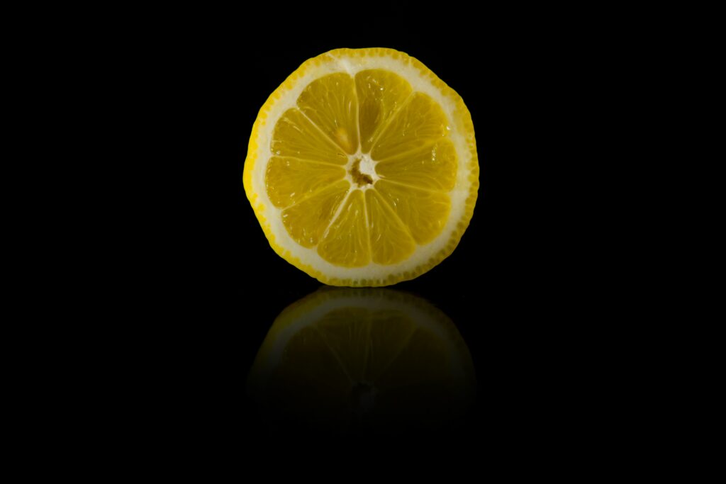 Lemon Slice Wallpaper: Glossy Citrus on Dark Minimalist Background