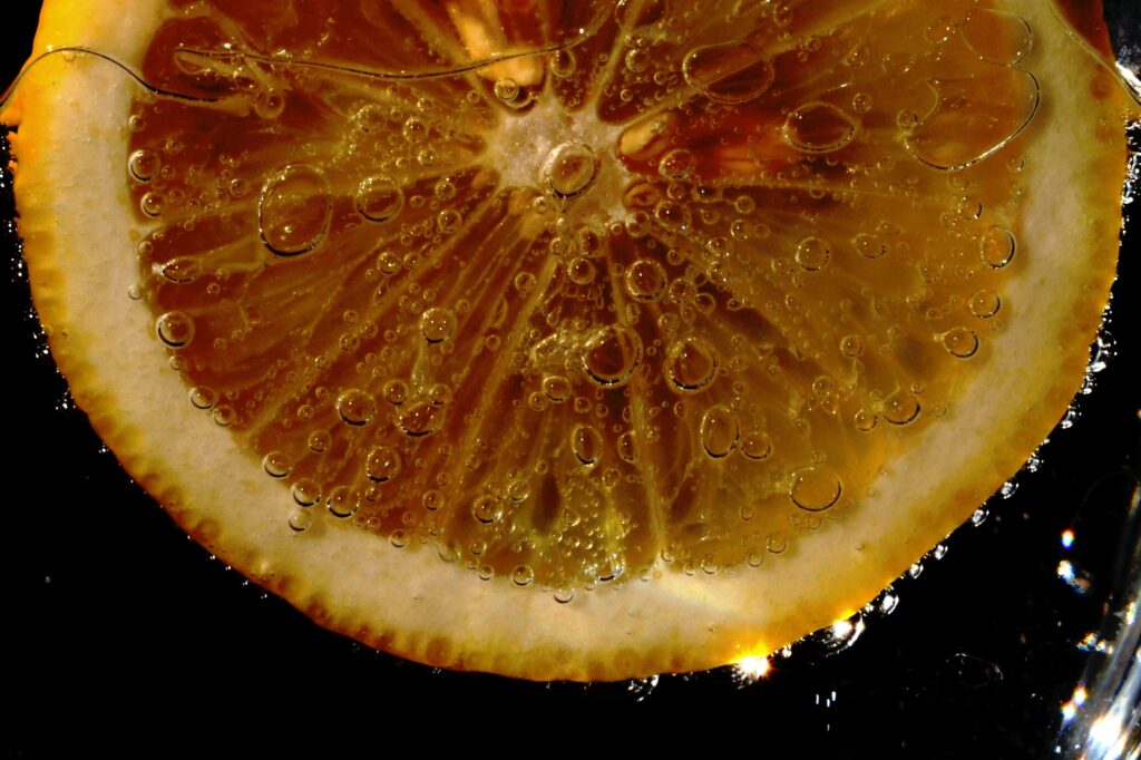Vibrant Lemon Slice in Liquid: Close-Up Detail Wallpaper Background