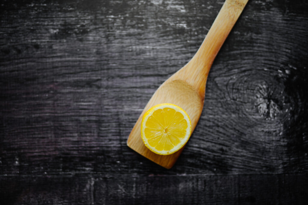 Fresh Lemon Slice on Wooden Spatula - Vibrant Citrus Wallpaper