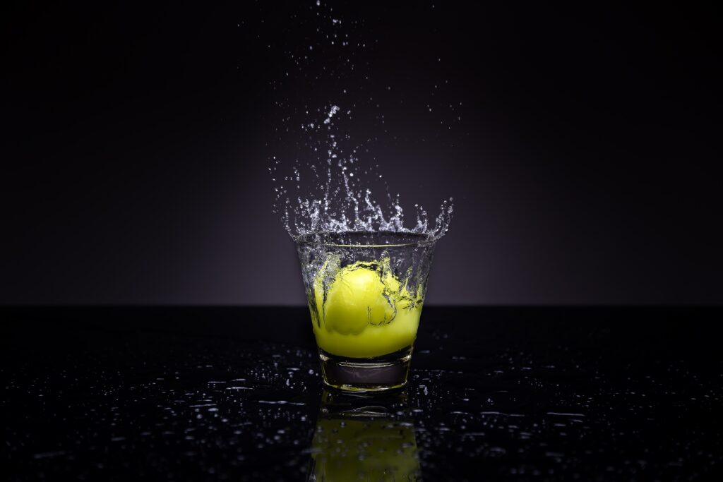 Vibrant Lemon Splash Wallpaper: Artistic Water Effect on Dark Background