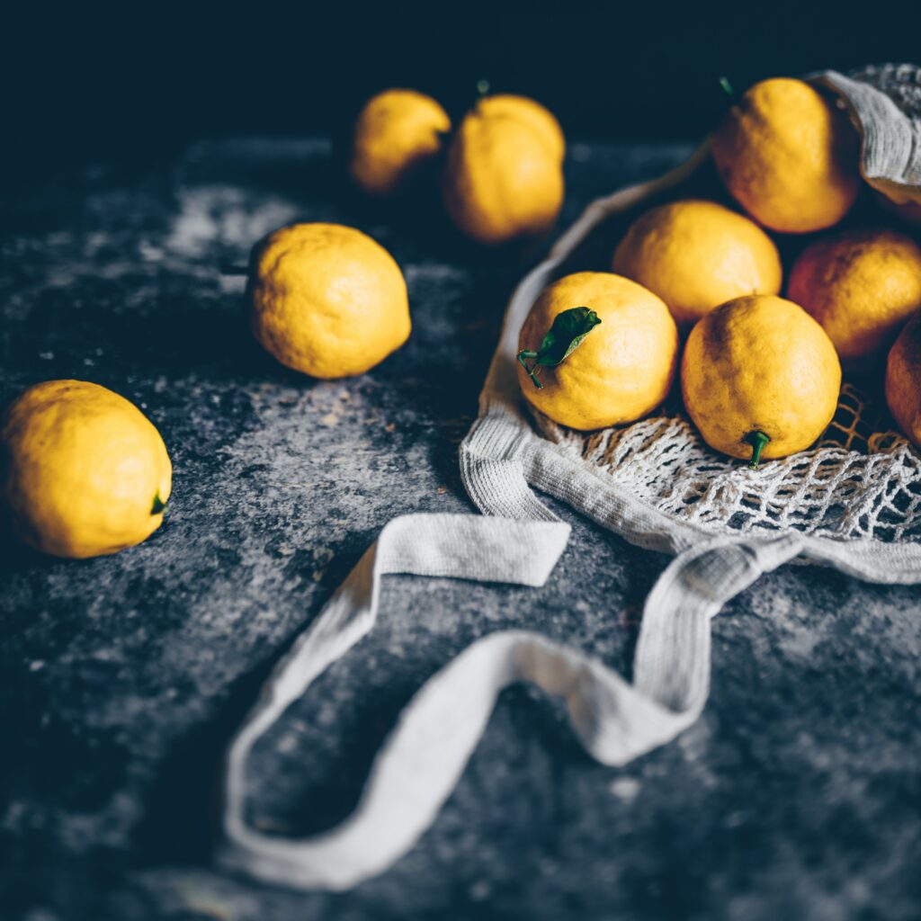 Vibrant Citrus Wallpaper: Yellow Lemons on Dark Textured Background