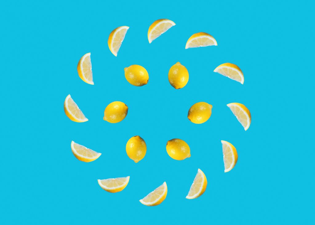 Vibrant Citrus Wallpaper: Whole Lemons & Slices on Blue Background