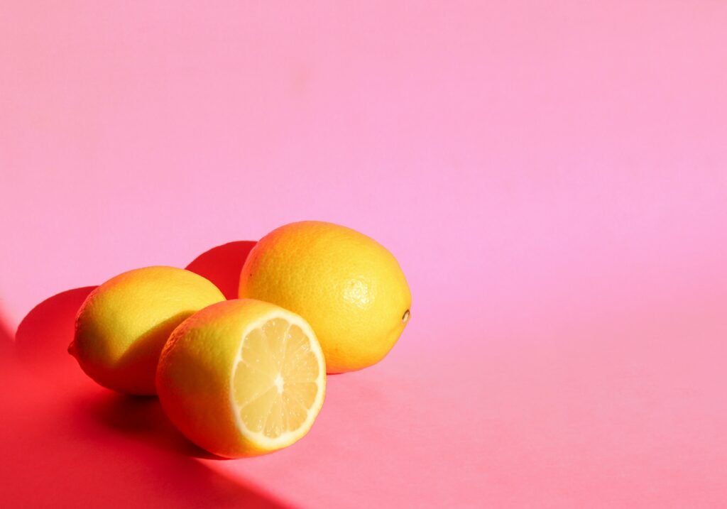Cheerful Wallpaper: Fresh Yellow Lemons on Bright Pink Background