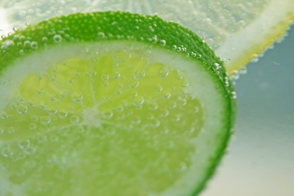 Vibrant Lime Slices in Bubbly Liquid - Refreshing Wallpaper Background