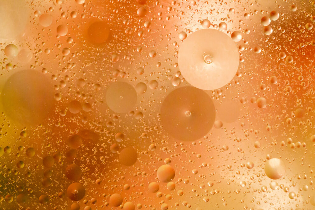 Vibrant Liquid Texture Macro Wallpaper with Glowing Yellow & Orange Bubbles