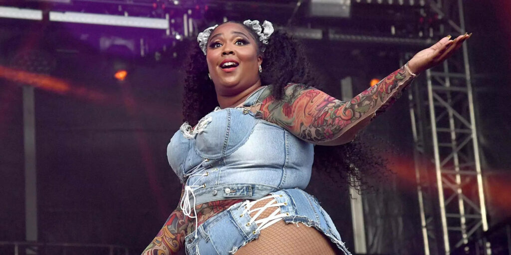 Vibrant Lizzo Wallpaper: Stylish Denim Performance Background