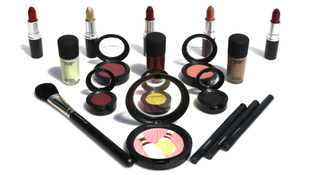 Vibrant MAC makeup products with lipsticks blushes eyeshadows and brushes on white background Wallpaper