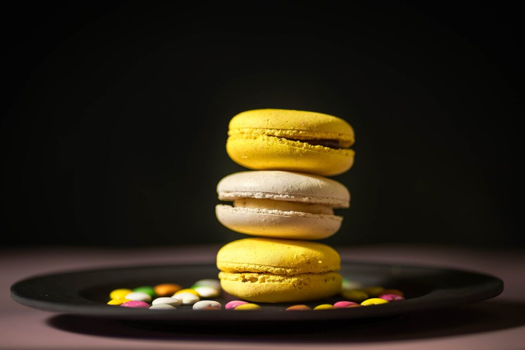 Colorful Macarons on Black Plate - Vibrant Dessert Wallpaper