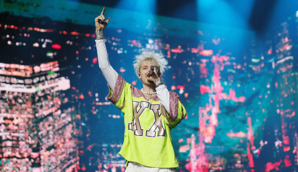 Vibrant Machine Gun Kelly Performance: Energetic Cityscape Wallpaper