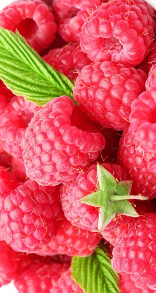Close-up of fresh ripe red raspberries with detailed texture and green leaves background wallpaper