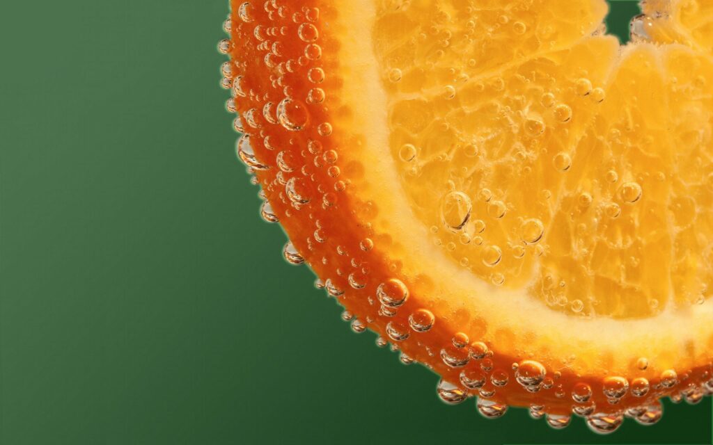 Vibrant Macro Wallpaper: Close-Up Orange Slice with Water Droplets