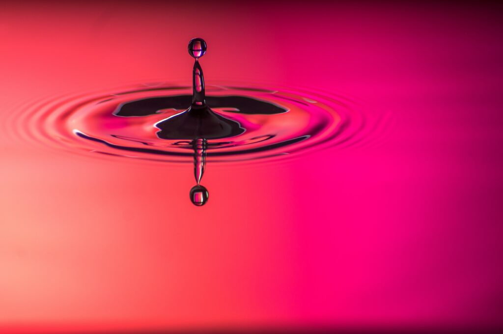 Vibrant Water Droplet Macro Wallpaper with Pink Gradient Background