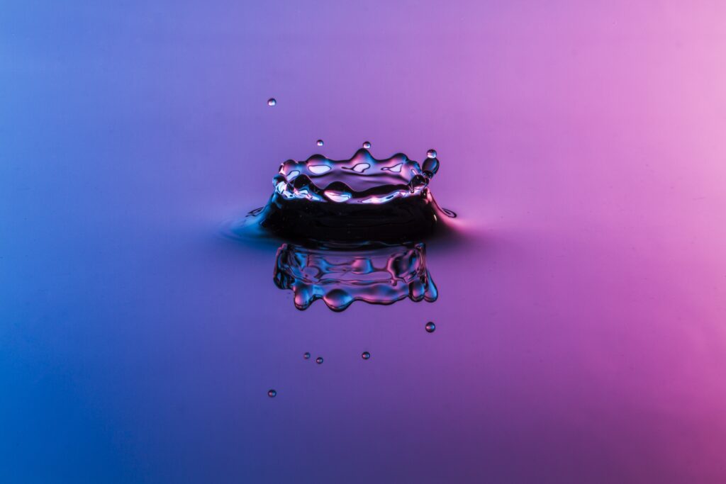Mesmerizing Water Droplet Splash: Blue to Pink Gradient Wallpaper