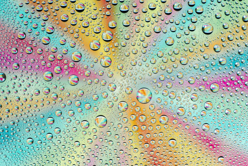Vibrant Wallpaper: Macro Water Droplets on Colorful Gradient Background