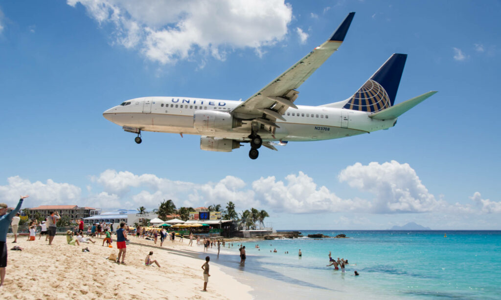 Maho Beach: Thrill of Low-Flying Plane Over Turquoise Waters Wallpaper