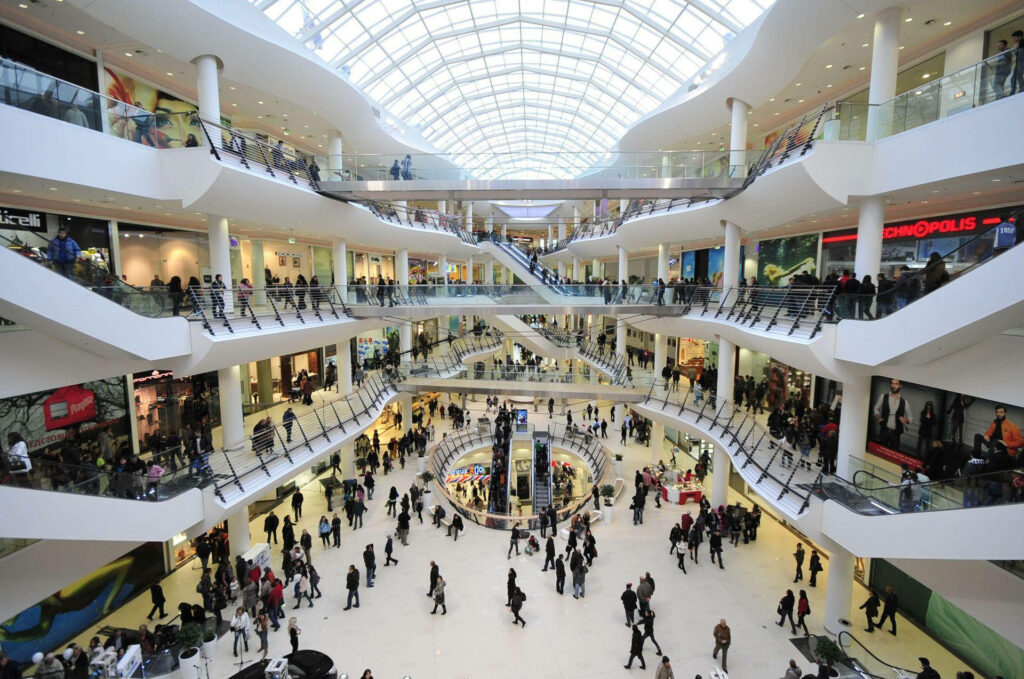 Vibrant interior of Mall Bulgaria Shopping Center with glass ceiling and bustling shoppers. Wallpaper
