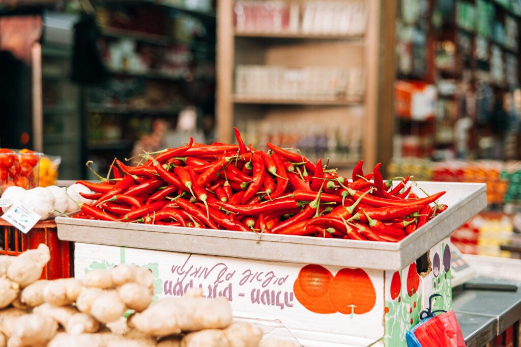 Vibrant Market Scene: Fresh Red Chillies & Colorful Background Wallpaper