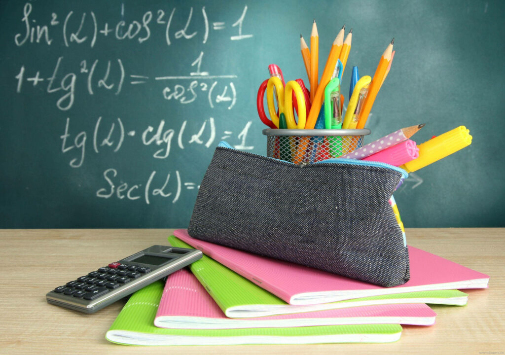 Chalkboard wallpaper with math formulas colorful notebooks calculator pencil pouch study scene