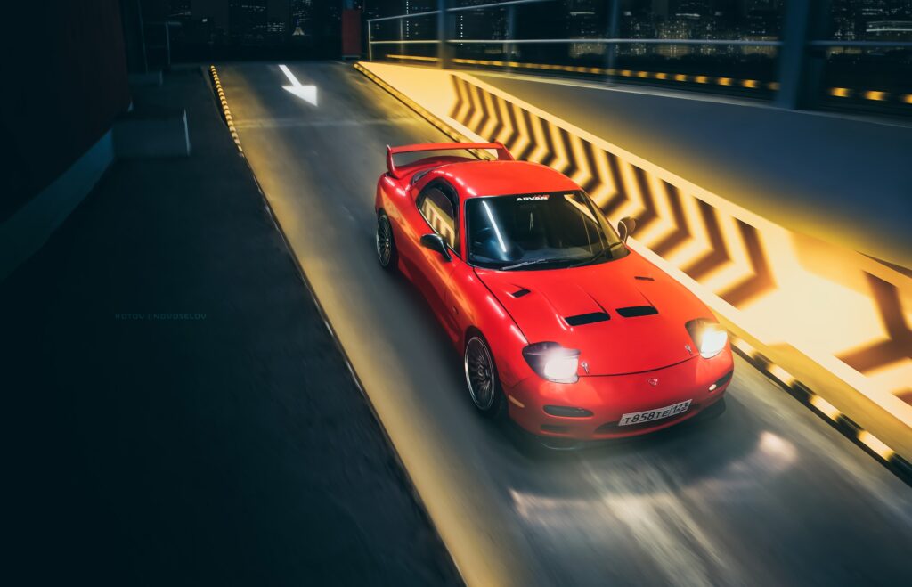 Vibrant Red Mazda RX-7: Nighttime Speed on a Racing Track Wallpaper