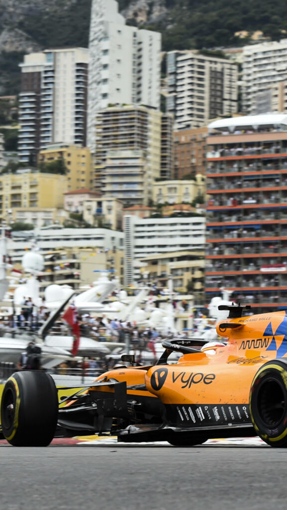 McLaren F1 Car Wallpaper: Vibrant Yellow-Orange in Cityscape
