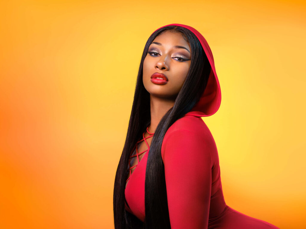 Vibrant Wallpaper: Megan Thee Stallion in Bold Red Against Orange