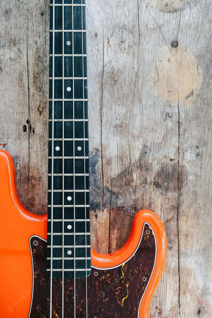 Rooted in Sound: A Vibrant Bass Guitar Melody on a Rustic Wooden Melody Wall Wallpaper